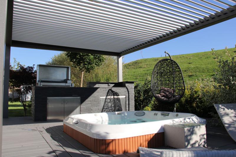 Pergola bio-climatique Biossun avec spa, bar et barbecue